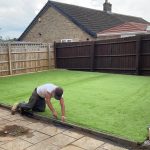 Installing fake grass in a garden in clare